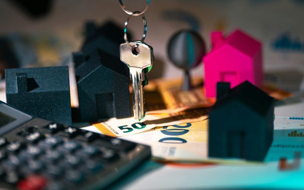 Calculadora, llaves y maqueta de casa